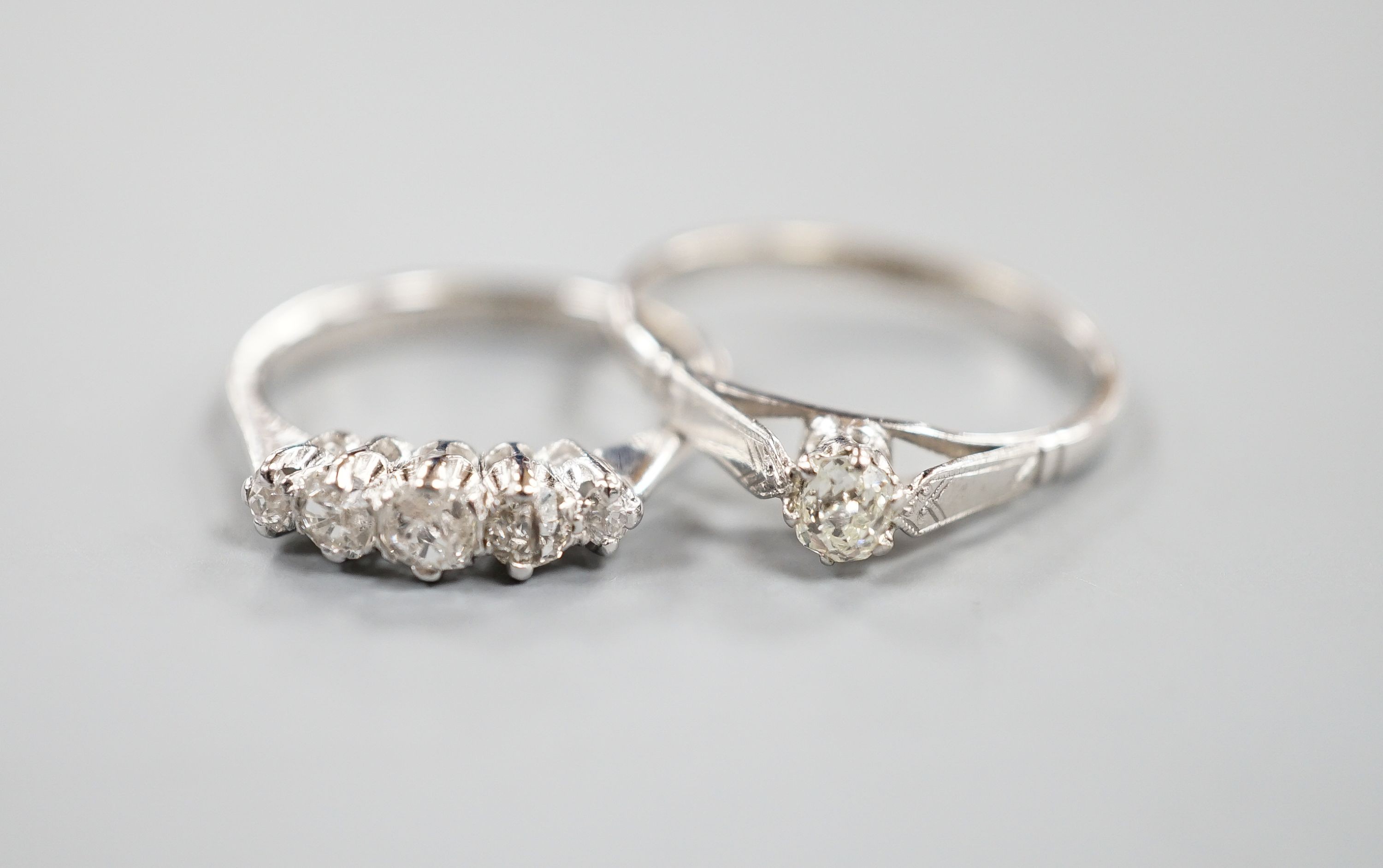 A modern 18ct gold and graduated five stone diamond set half hoop ring, size L and an 18ct and plat, solitaire diamond ring, size P/Q, gross weight 5.1 grams.
